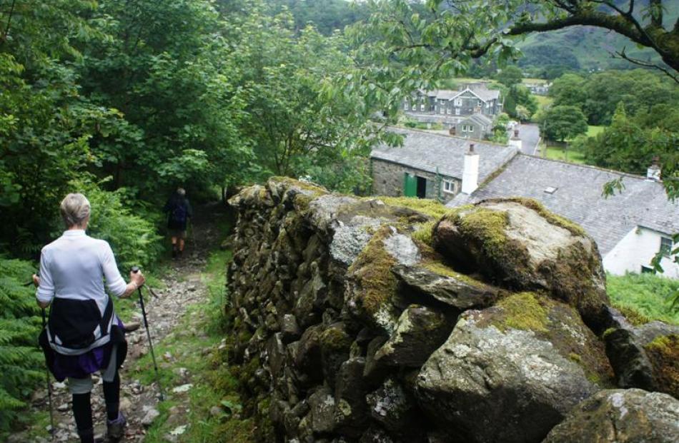 Hikers navigate slippery trails on the descent into the Cumbrian village of Grange.