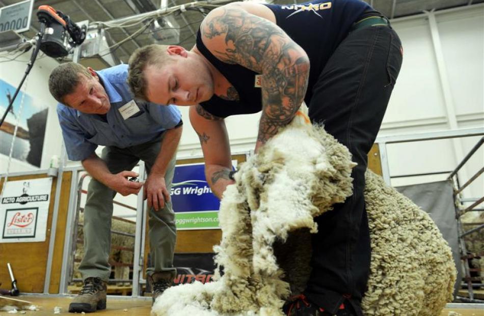 Judge Fred Parker keeps a close eye on Andrew Eade as he competes in the merino shearing heats.