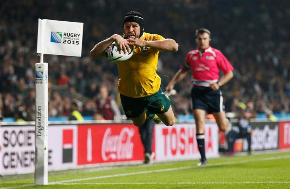 Australia second five-eighth Matt Giteau dives to score their third try in a 33-13 win over...