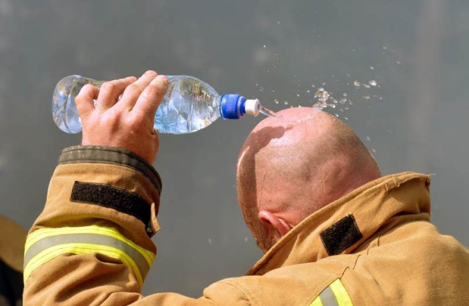 Fire fighter Craig Brown lowers his tempature after removing breathing aparatus while fighting...