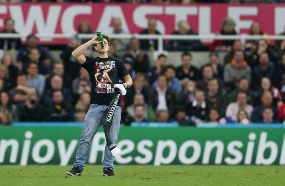 A pitch invader stops to have a drink during New Zealand's game against Tonga. Photo: Reuters