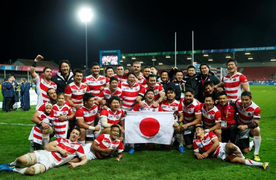 Japan players celebrate after beating the USA 28-18, their third win of the World Cup. Photo:...