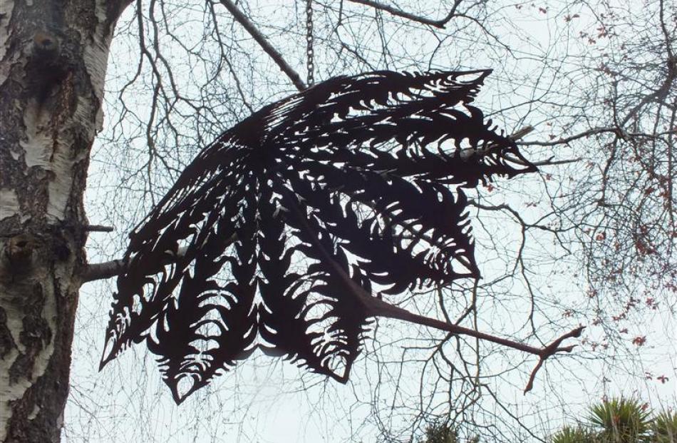 A metal sculpture in a silver birch.