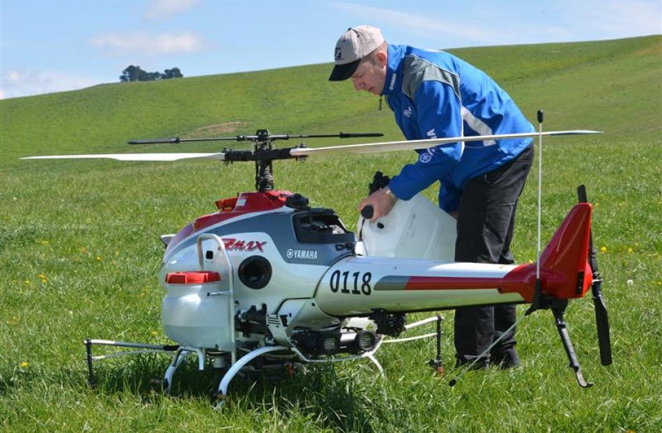 Geoff Lamb, of Yamaha Sky Division,  tops up spray tanks for a demonstration of the company's...