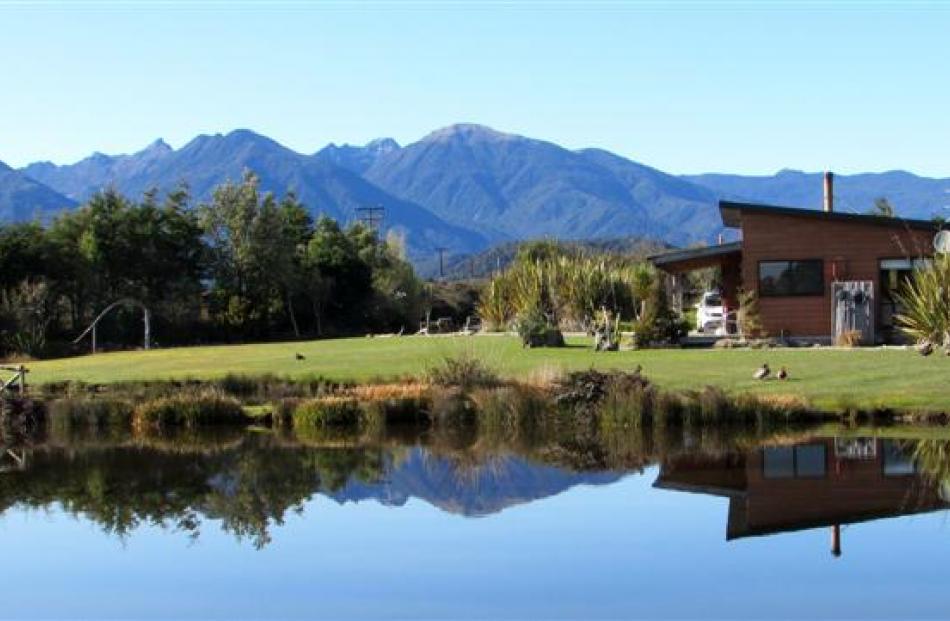 Birds Ferry cottage set against the Paparoa mountains.