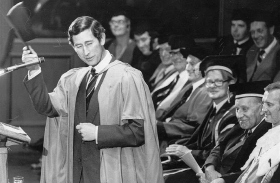 Prince Charles waves his trencher after receiving an honorary doctor of literature degree from...