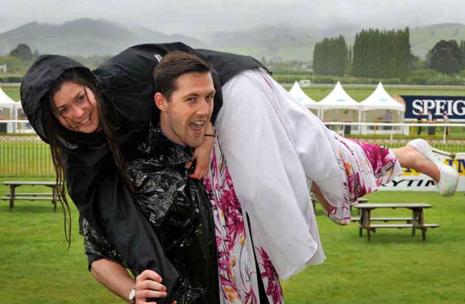 Samuel Marmion carries Stella Lisle over muddy ground after she struggled with high heels in the ...