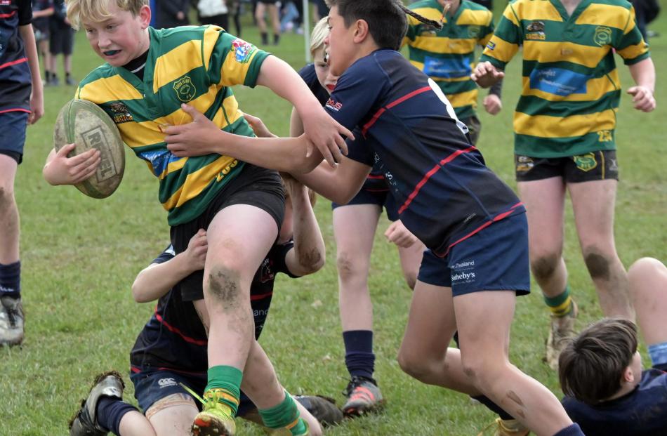 Cooper Wilde, of Green Island, tries to shrug off the defence of Malaki Sefo, of Arrowtown.

