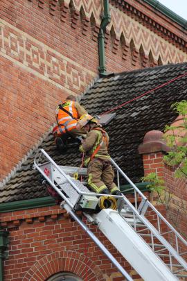 Firefighters try to get access to a manhole after smoke was seen in walls and roof voids of the...