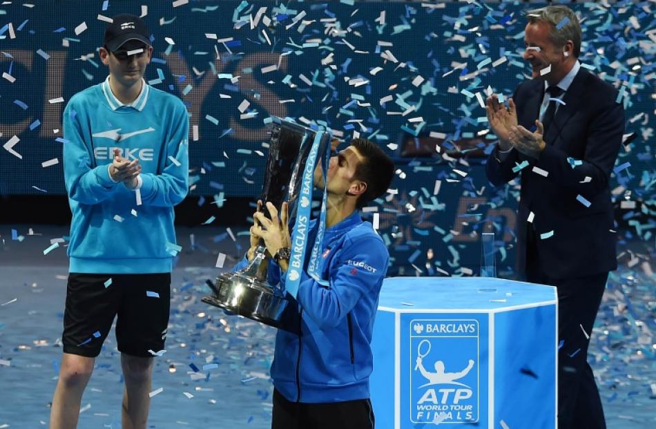 Novak Djokovic kisses the trophy after winning the ATP World Tour Finals, beating Roger Federer...