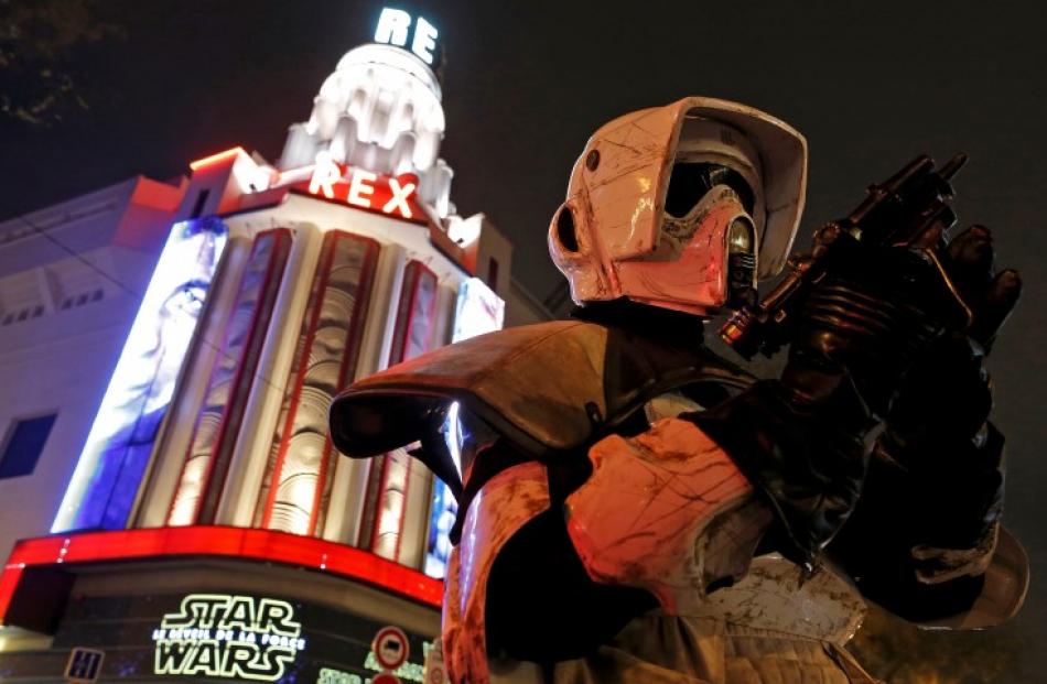 A costumed fan poses in front of the Grand Rex cinema in Paris, France.