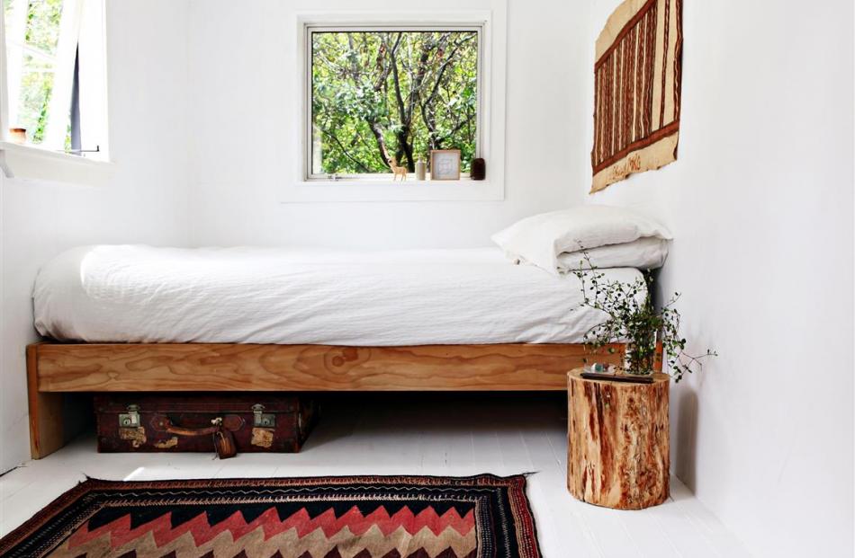 The rug and bark tapa cloth add warmth. Part of a log was turned into a bedside table.