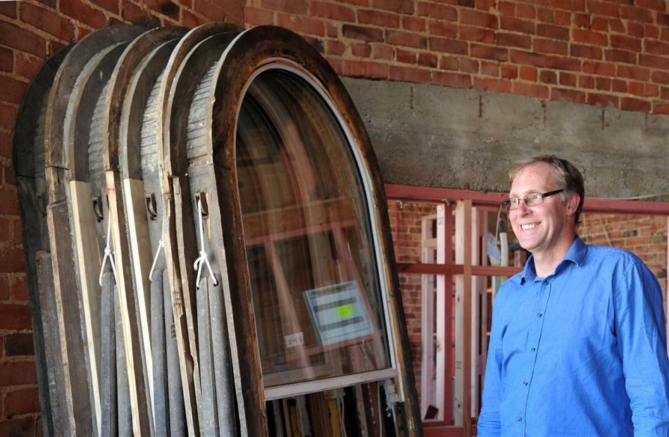 Building owner Stephen Macknight and a collection of 135-year old window frames fitted with new...