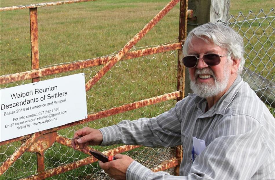 Waipori historian David Still attaches a reunion notice to the Waipori Cemetery gate.