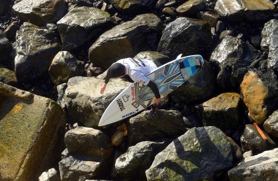 Taranaki surfer Jarred Hancox tackles the surf and  braves  the rocks on St Clair Beach during...
