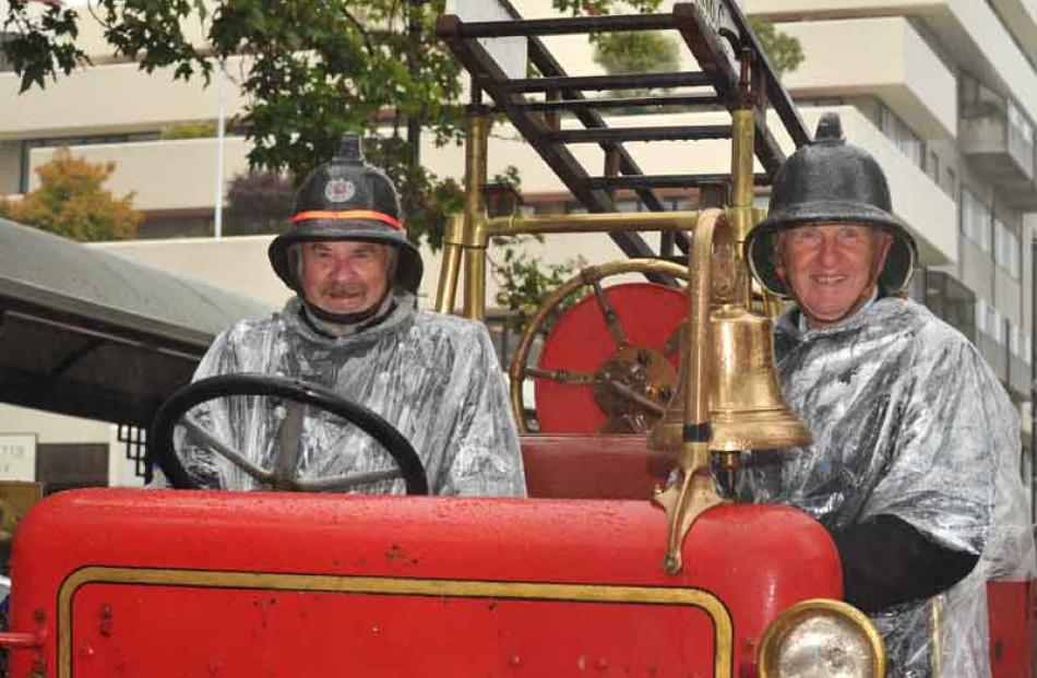 Retired firemen (from left) Tom Churchill and Lawson Baird (both of Dunedin) ignore the rain...
