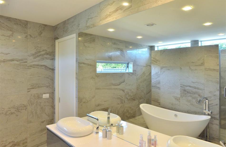 The wall behind the bathtub hides the shower and toilet from view in the en suite.