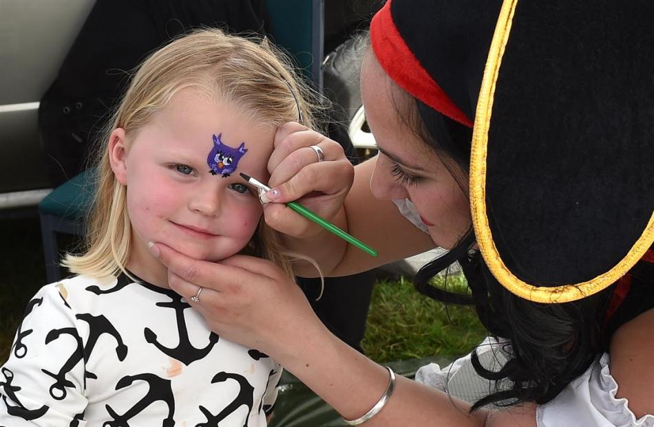 Evie Cross (3) of gets her face painted by Becky Clinch at the Little Rock Preschool stall.