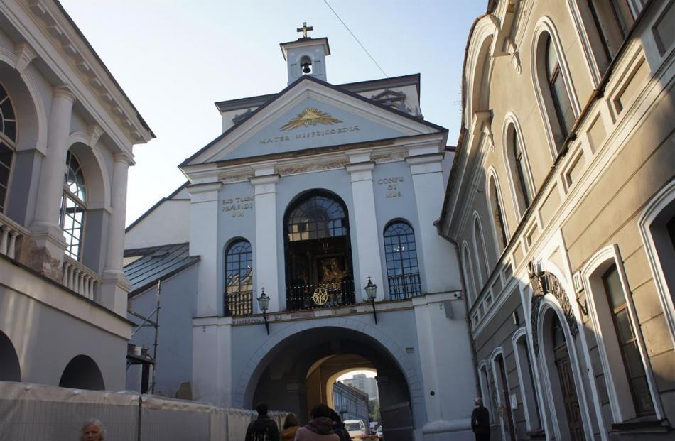 Visitors ponder the Gates of Dawn, and above, the popular pilgrimage point of the Chapel of the...