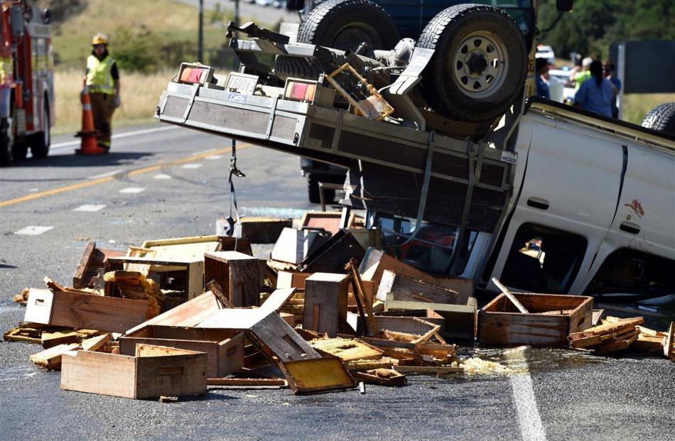 The upturned ute, with beehives spread over the road.