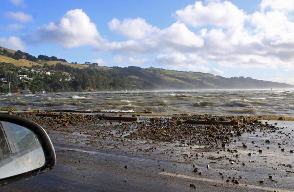 Debris litters the road at Macandrew Bay. Facebook/Macandrew Bay Community Page