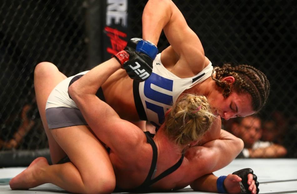 Miesha Tate pins Holly Holm to the ground during the UFC fight. Photo: Reuters