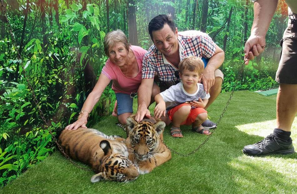 Winston Aldworth, son Baxter and mother Heather meeting tiger cubs at Dreamworld.