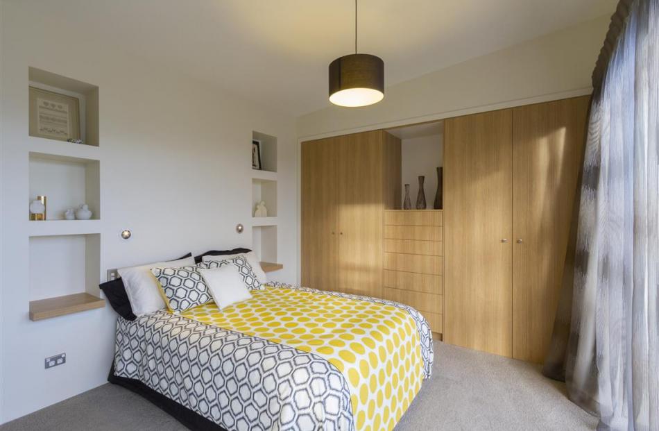 The main bedroom has built-in shelving, his-and-hers wardrobes and a spacious en suite bathroom.