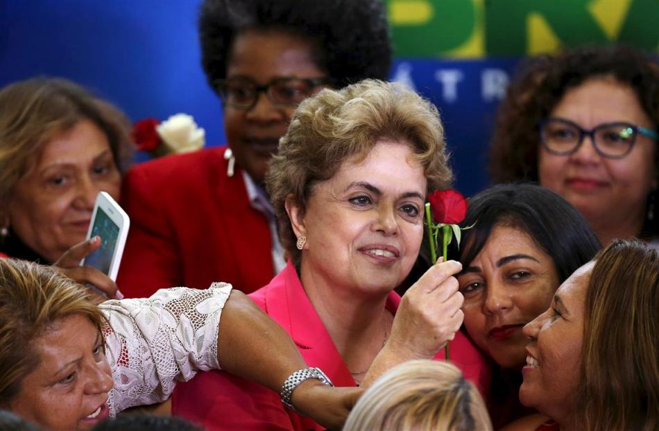 Mrs Rousseff raises a rose during the meeting ‘‘Women in Defence of Democracy’’  in Brasilia last...