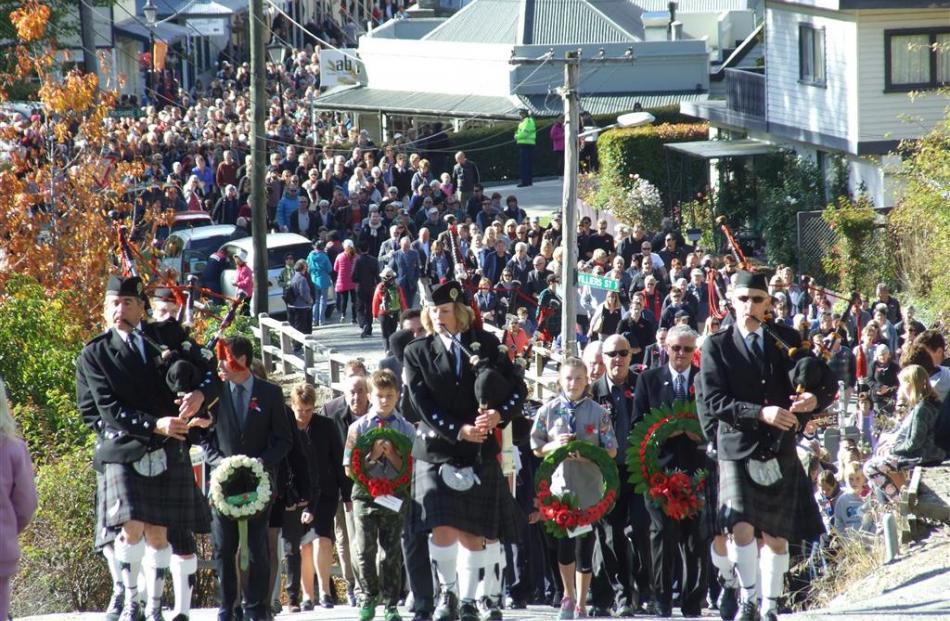 The Queenstown and Southern Lakes Pipe Band leads thousands of people to the War Memorial in...