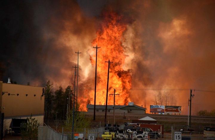 The wildfire burns in an industrial area in the southern part of Fort McMurray, Alberta. Photo...