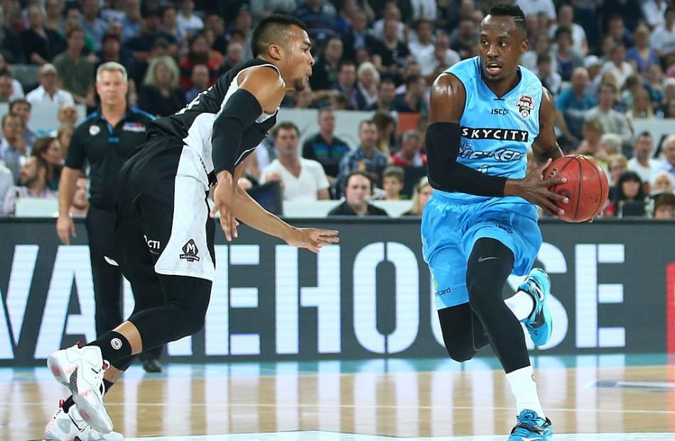 Cedric Jackson looks to drive to the hoop for the Breakers as Stephen Holt of Melbourne United...