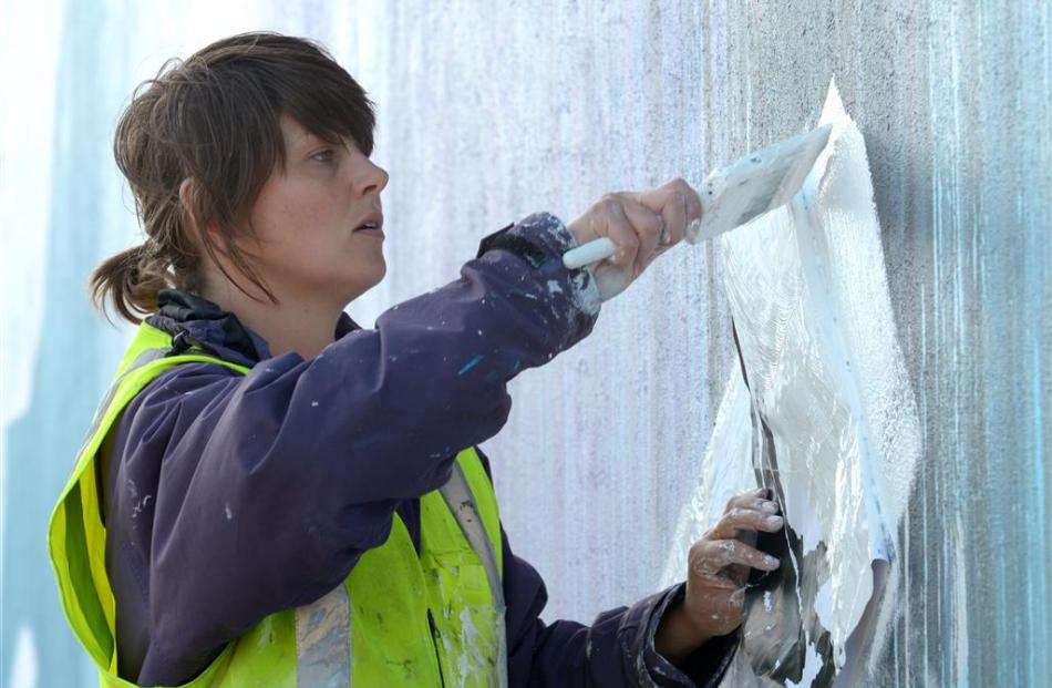 Artist Tess Sheerin, of Queenstown,  works on a mural yesterday that she is creating on the side...