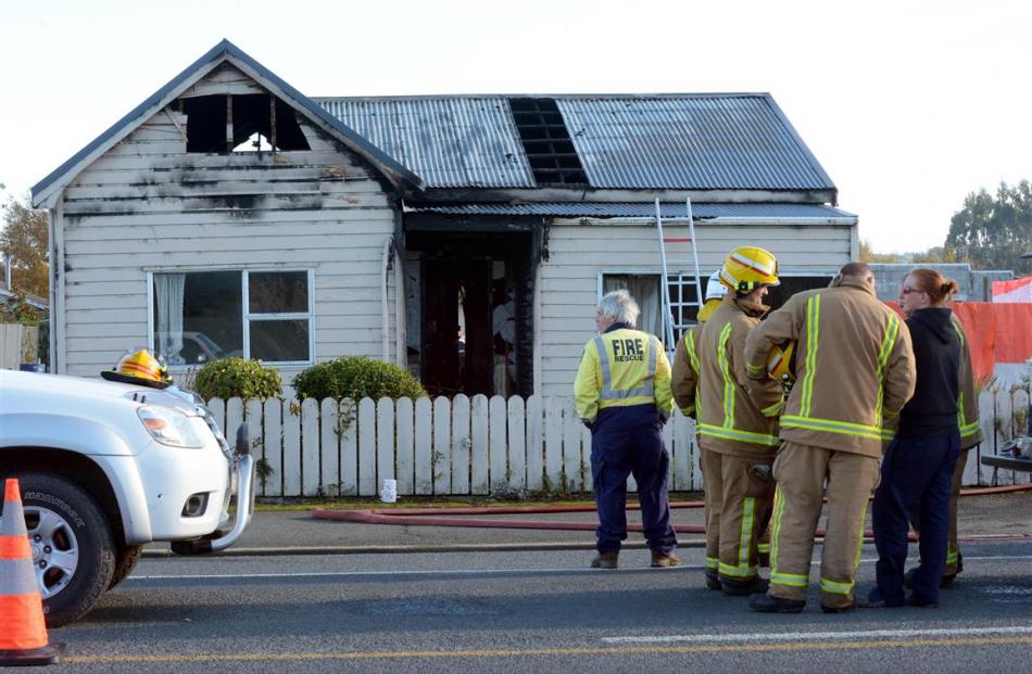 Firefighters talk to a woman outside the Union St house. Photos by Gerard O'Brien.