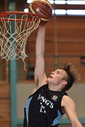 King’s High School basketballer Olly Crombie powers in the ball in the interschool match against...