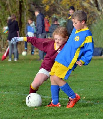 Grace Barnes (8, left), of Maori Hill Crimson, and Sam Drake (7), of Melchester Strikers, vie for...