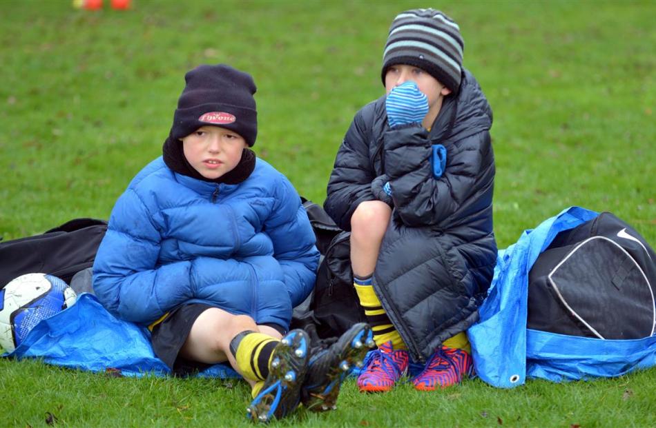 Travis Nevell (left) and Jack Flanagan (both 8), of Grants Braes Vipers, try to stay warm while...