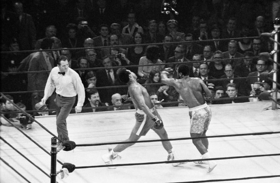 Muhammad Ali lands a left hook against Joe Frazier in their first fight in 1971. Photo: Reuters