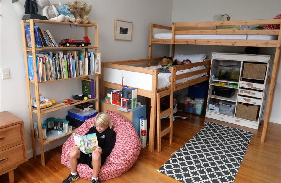 Lucas MacLeod (8) relaxes in his bedroom.