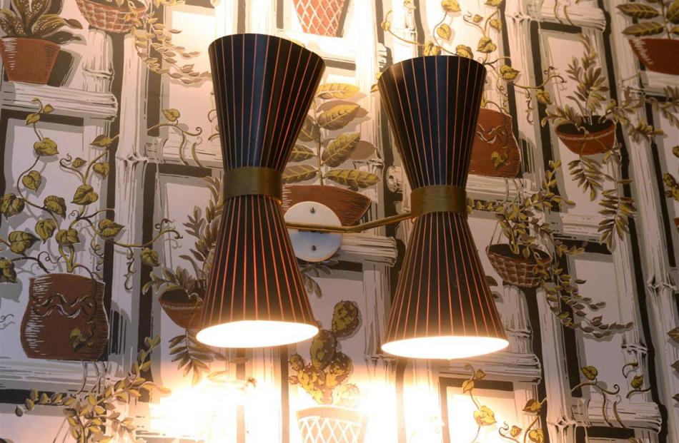 Original hourglass-shaped lights illuminate wallpaper with a pot-plant motif.