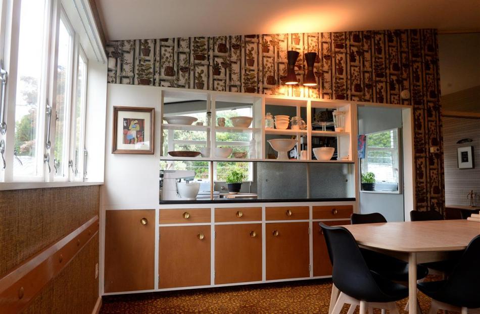 The dining area is separated from the kitchen by built-in cupboards, some of which have had doors...