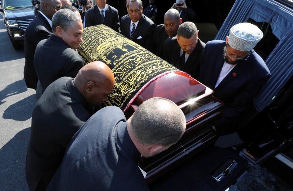 Pallbearers place Muhammad Ali's casket in the hearse as it prepares to begin a procession...