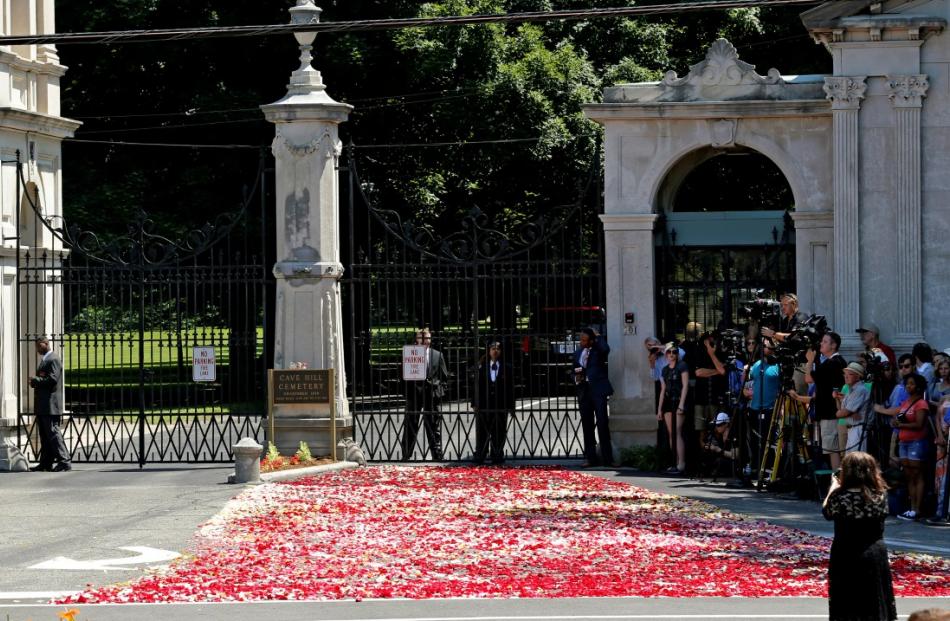 Rose petals are spread out over the main entrance to Cave Hill Cemetery ahead of the arrival of a...