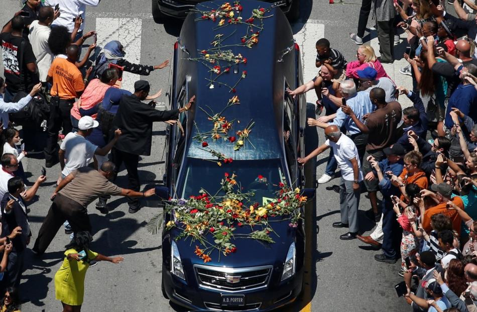 Well-wishers touch the hearse carrying the body of the late boxing champion Muhammad Ali during...