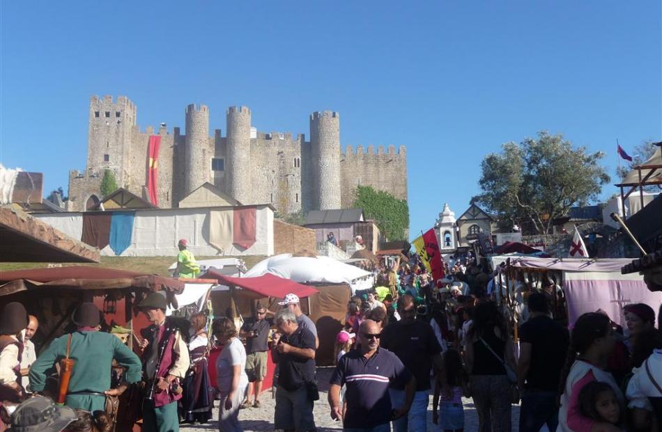 Crowds wander the cobblestoned streets of Obidos during its annual medieval fair.