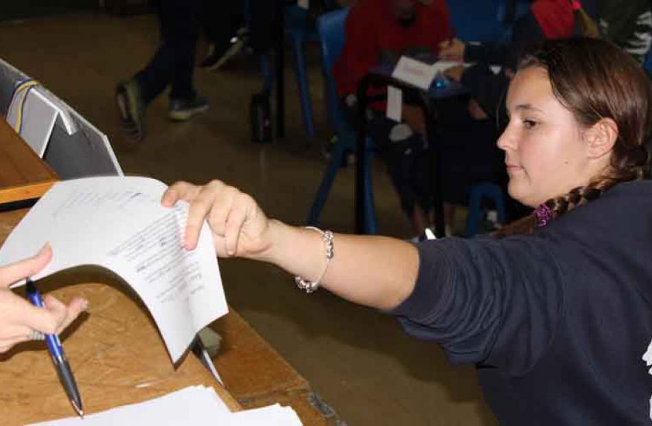 Aimee Clark (12) of Queenstown Primary School hands in her team's sheet at the Otago Daily Times...