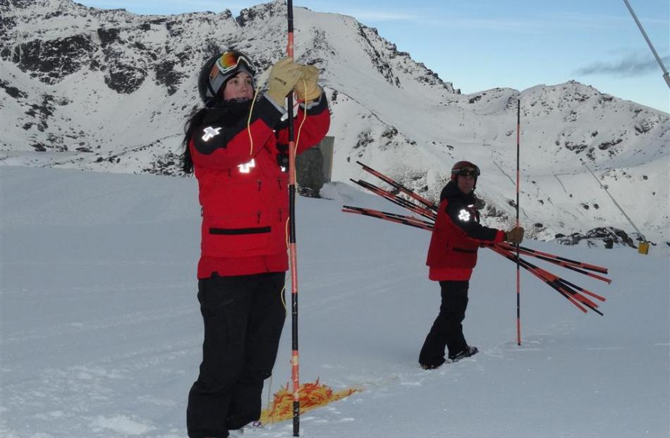 Ski patrollers Kaitlin Bowles (left) and Michel Lepage set up hazard ropes.