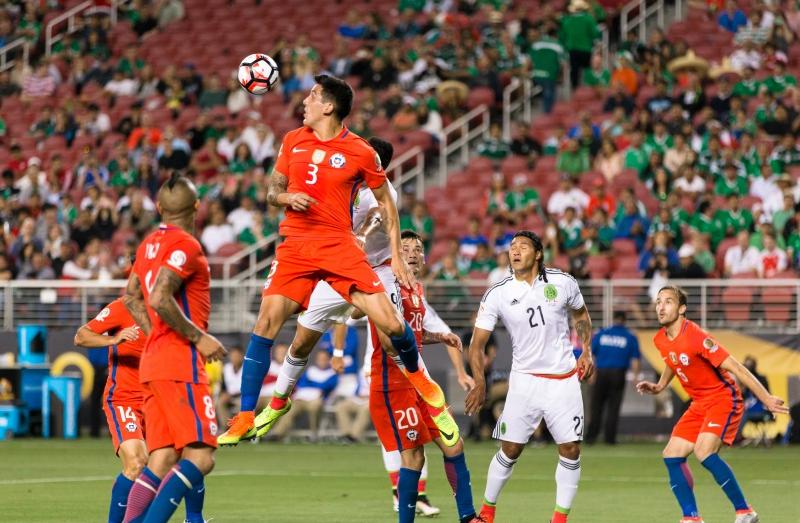 Chile defender Enzo Roco (3) heads the ball clear after a corner kick by Mexico during their Copa...