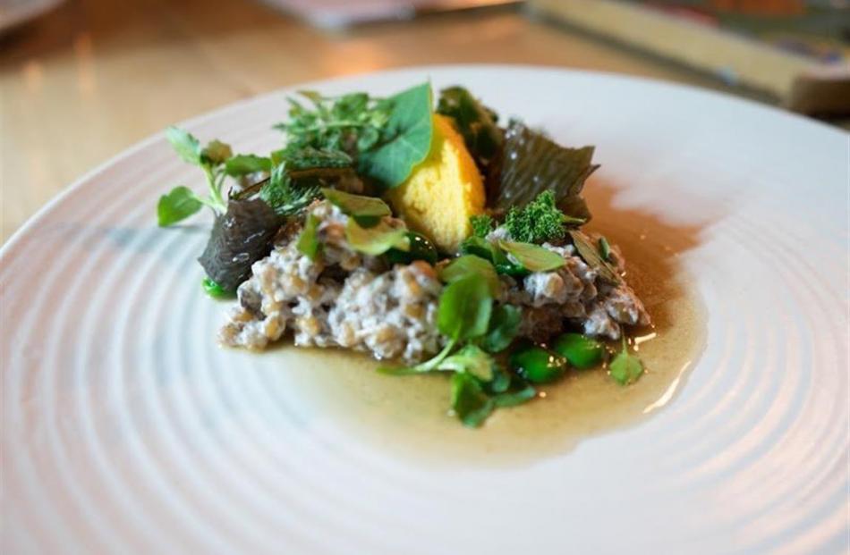 A dish of whole wheat grains with wild mushrooms, seaweed, egg yolk and foraged herbs, is one of...