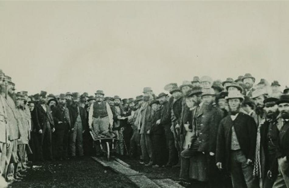 James Macandrew, with wheelbarrow, turned the first sod of the centrally funded Invercargill...